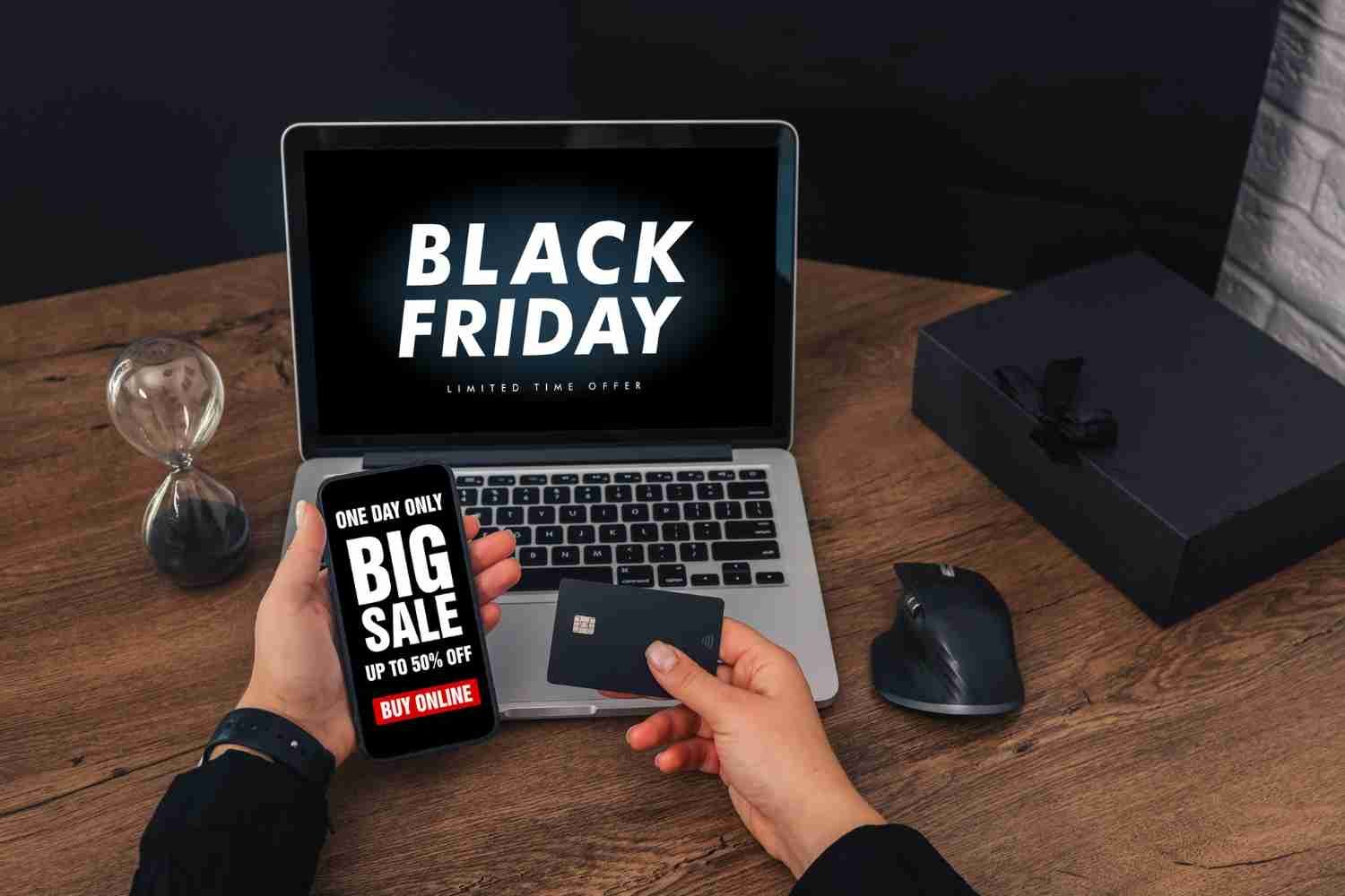 mujer sosteniendo-tarjeta de credito escribiendo teclado portatil venta black friday en pantalla